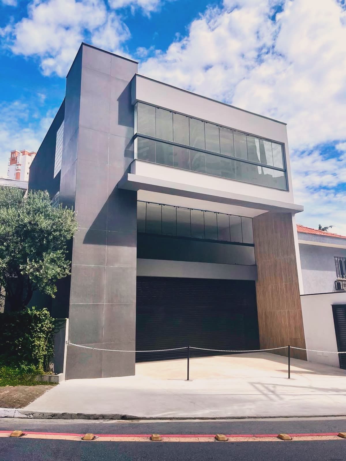 Edifício com volume em balanço e fachada de vidro